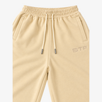 STF cream oversized wide-leg joggers — waistband embroidery and drawstring detail