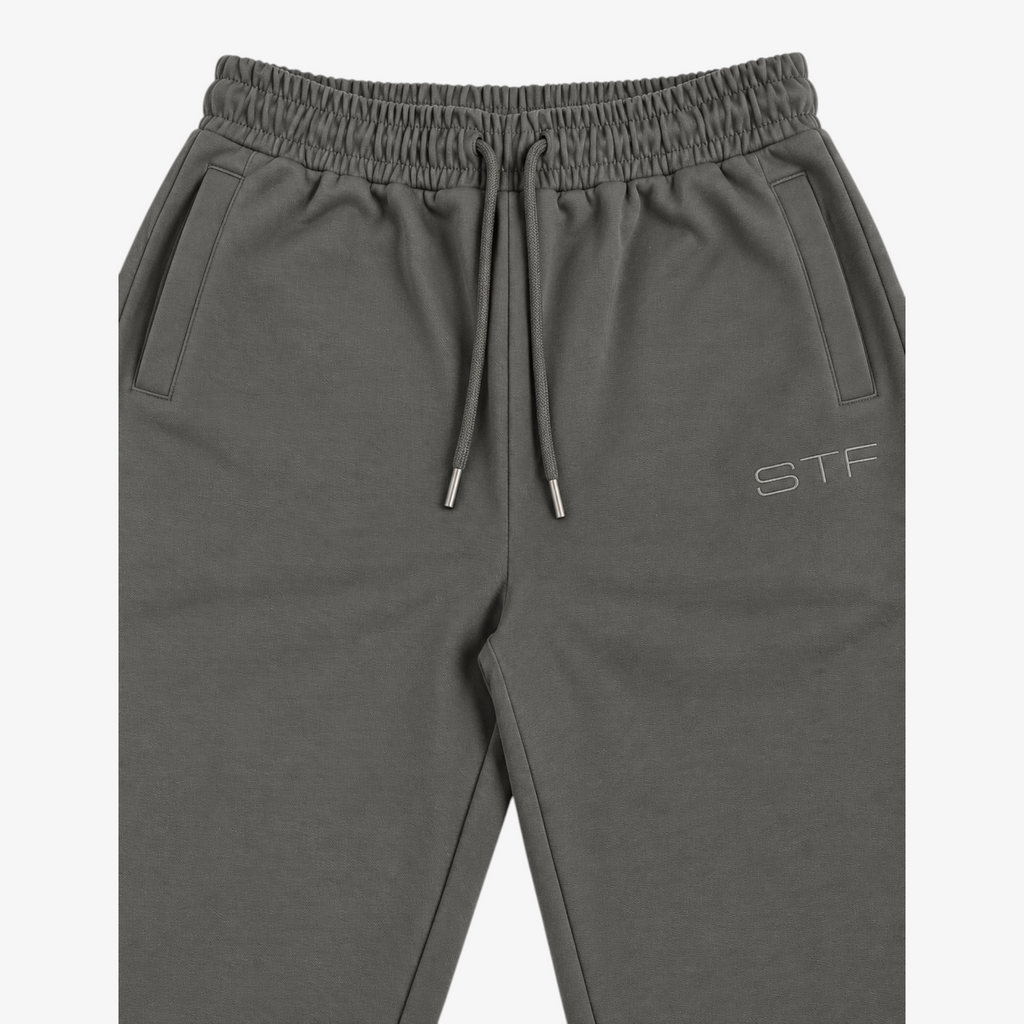 STF grey relaxed open-hem trousers — waistband and embroidery detail