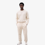 Model wearing Seejthreadsflames (STF) Essential Jogger in cream heavyweight fabric with elasticated cuffs and waist.