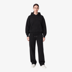 Female model wearing the STF black heavyweight tracksuit, front view